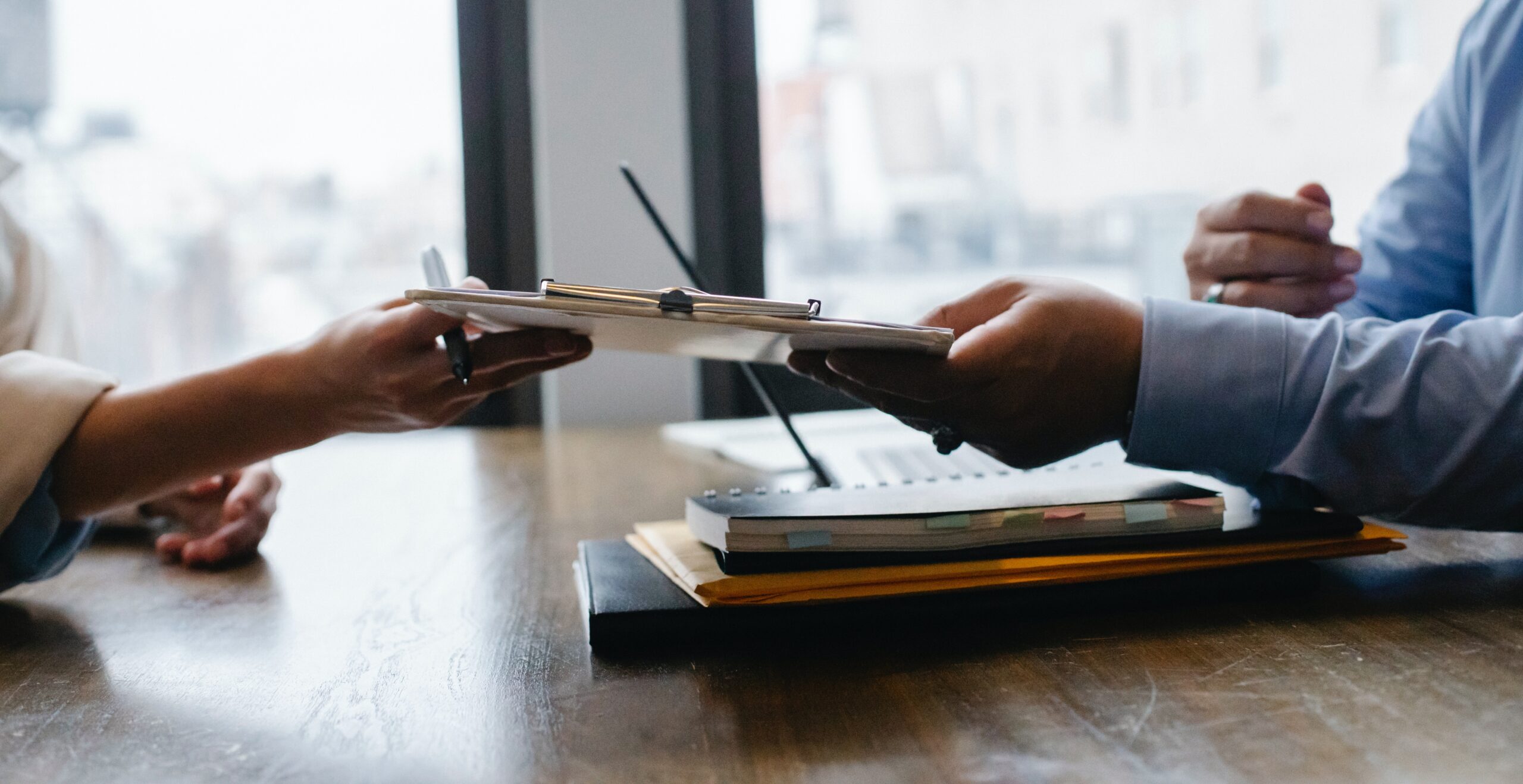 A person handing over a form and providing service to a clerk.