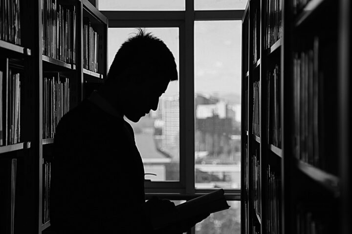 Dark silhouette of a student in a library.