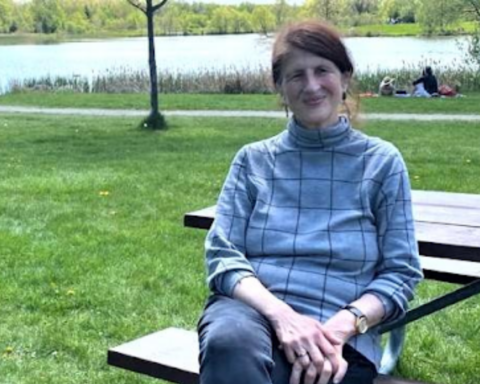 Canadian activist Jill Carr-Harris sits on a park bench.