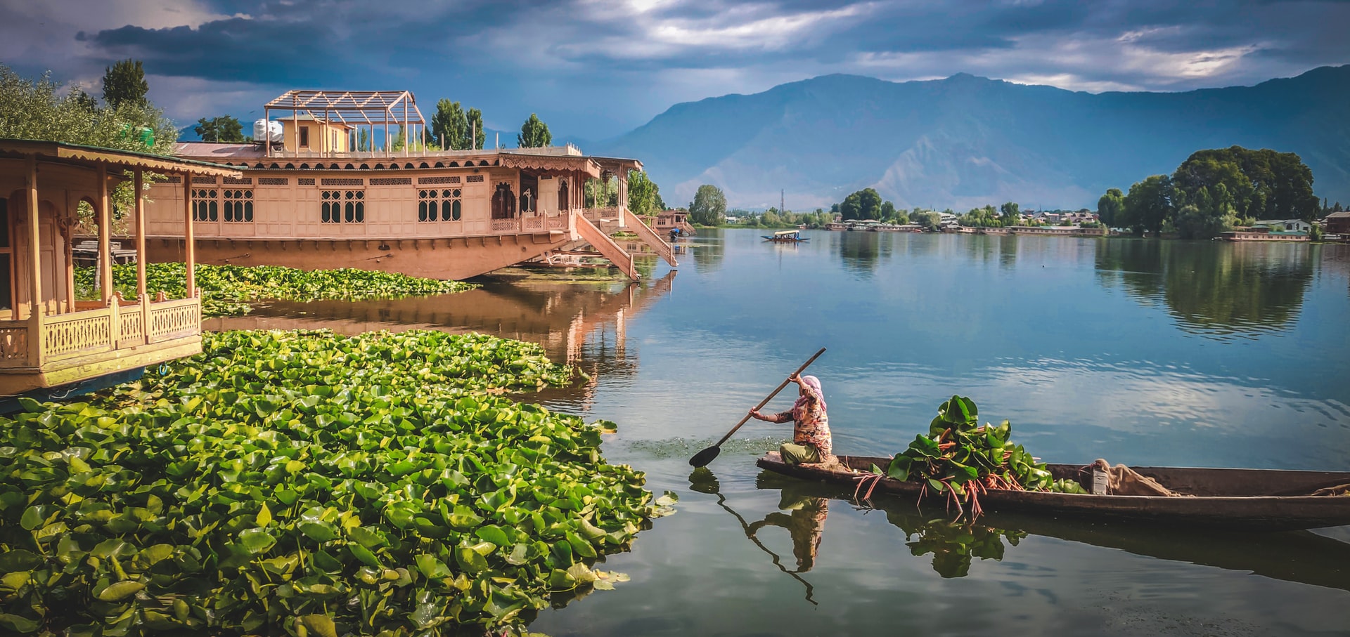 A woman rowing a boat known as "Shikara" in Srinagar, Kashmir, where the novel "Life in the Clock Tower Valley" is set.