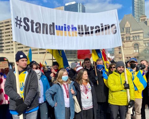 Deputy Prime Minister Chrystia Freeland and Toronto mayor John Tory pose for a picture with a group of protesters clad in blue and yellow at Toronto march to protest Russia's invasion of Ukraine..