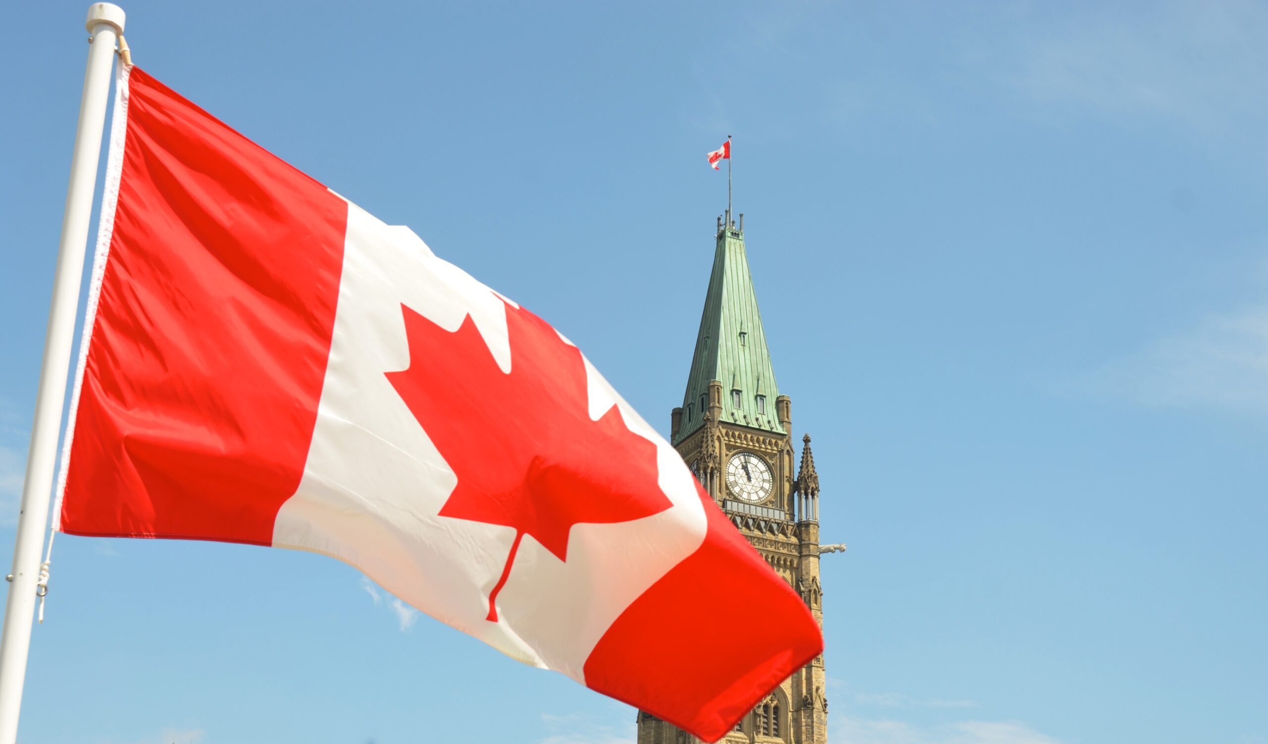 Drapeau canadien flottant devant l'édifice du Parlement sur la colline du Parlement à Ottawa.