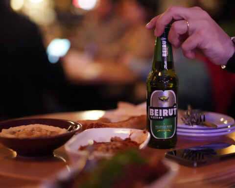 Un homme tient une bouteille de bière "Beirut"