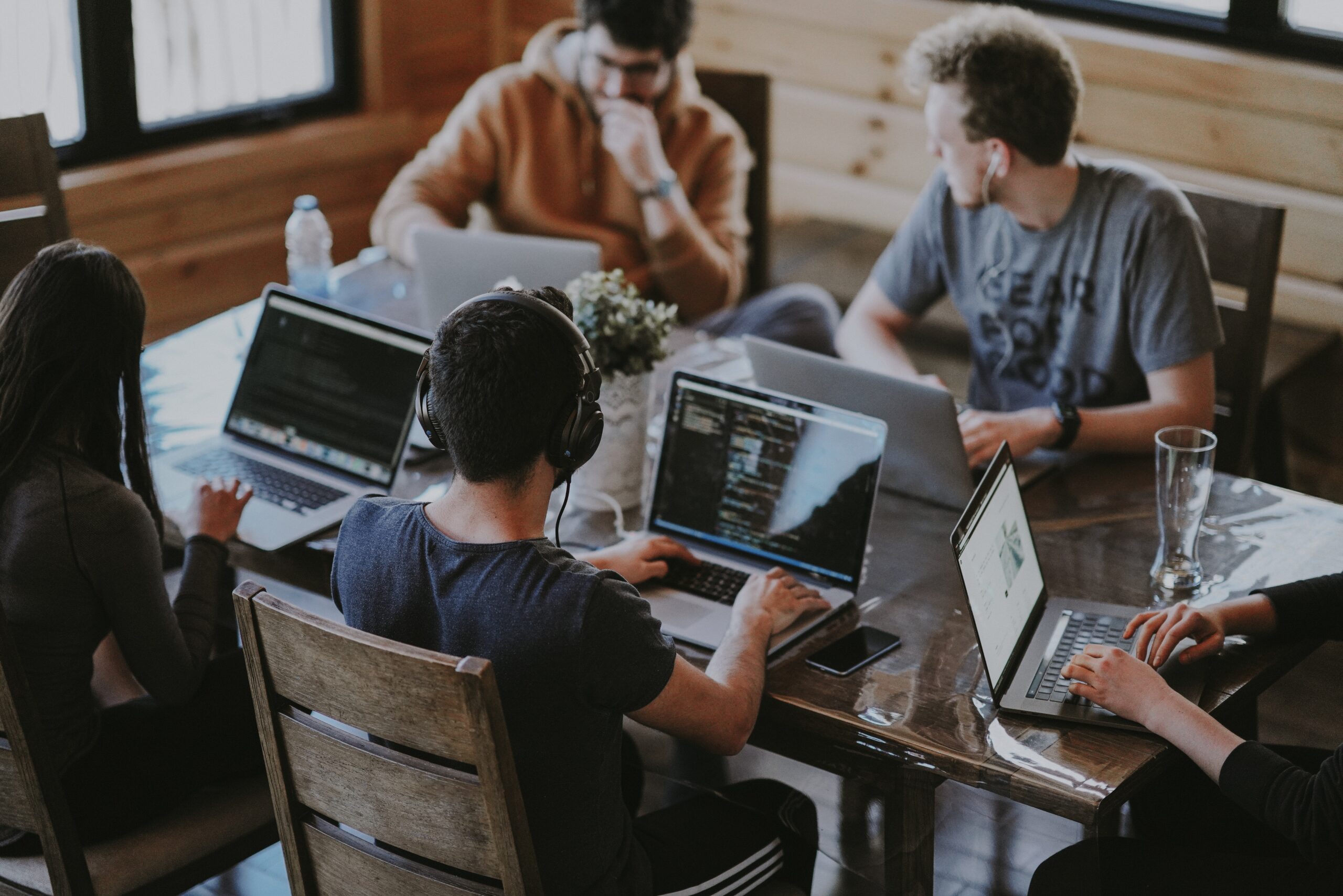 tech and digital workers sit around a table with computers