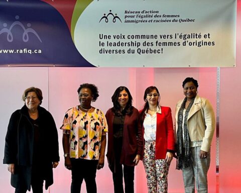 Une groupe des femmes posent devant une bannière du RAFIQ