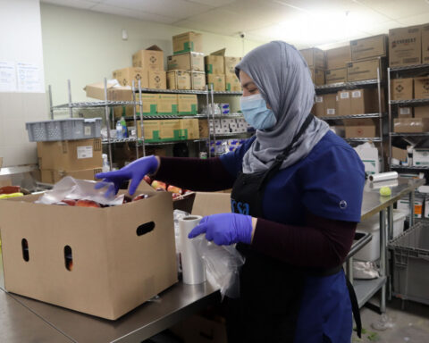 A volunteer at Agincourt Community Services Association food bank sorts produce.