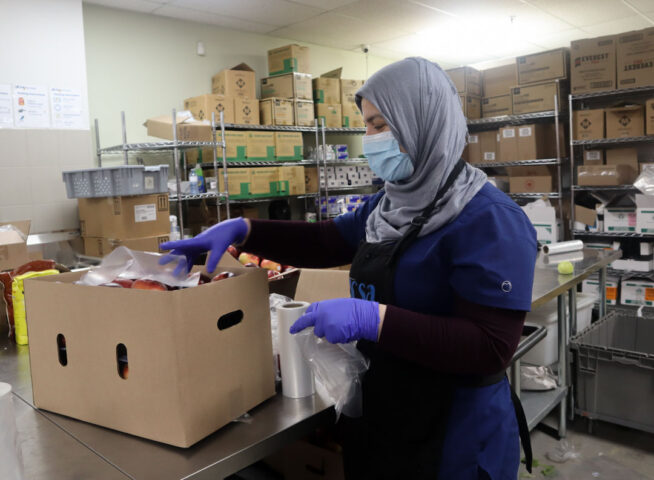 A volunteer at Agincourt Community Services Association food bank sorts produce.