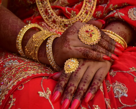South Asian woman wearing mehendi and gold jewellery
