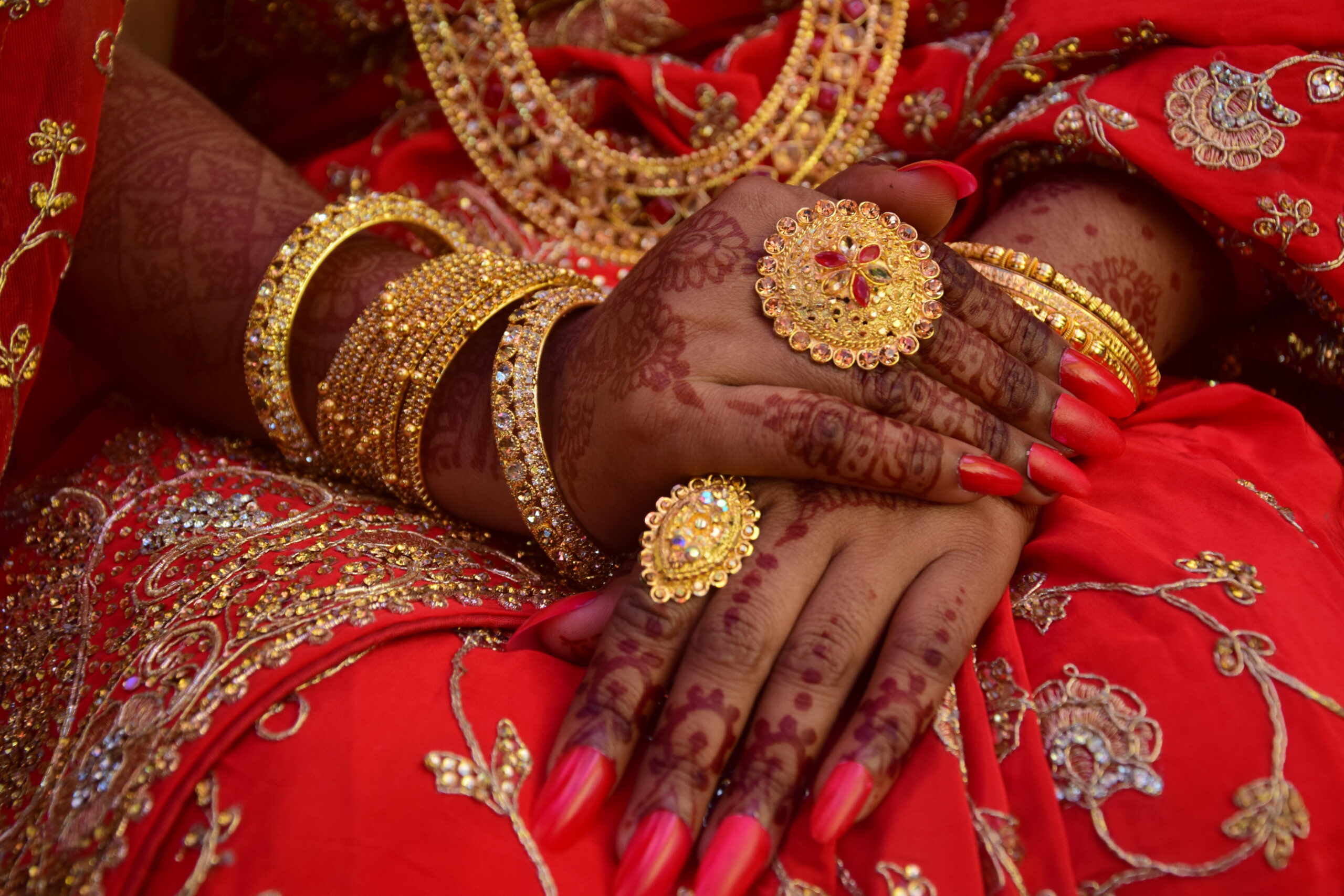 South Asian woman wearing mehendi and gold jewellery