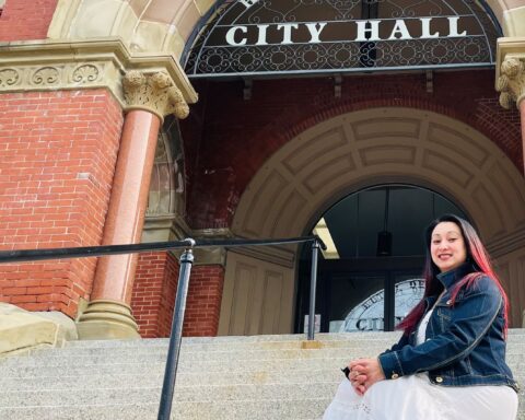 Le Farris, of Keswick Ridge, a small rural community northwest of Fredericton, in front of Fredericton City Hall. Farris fled Vietnam in the 1970s with her family by boat and started a new life in Canada. She encourages new Canadians to embrace the culture of their adopted land. (Michael Staples/New Canadian Media)